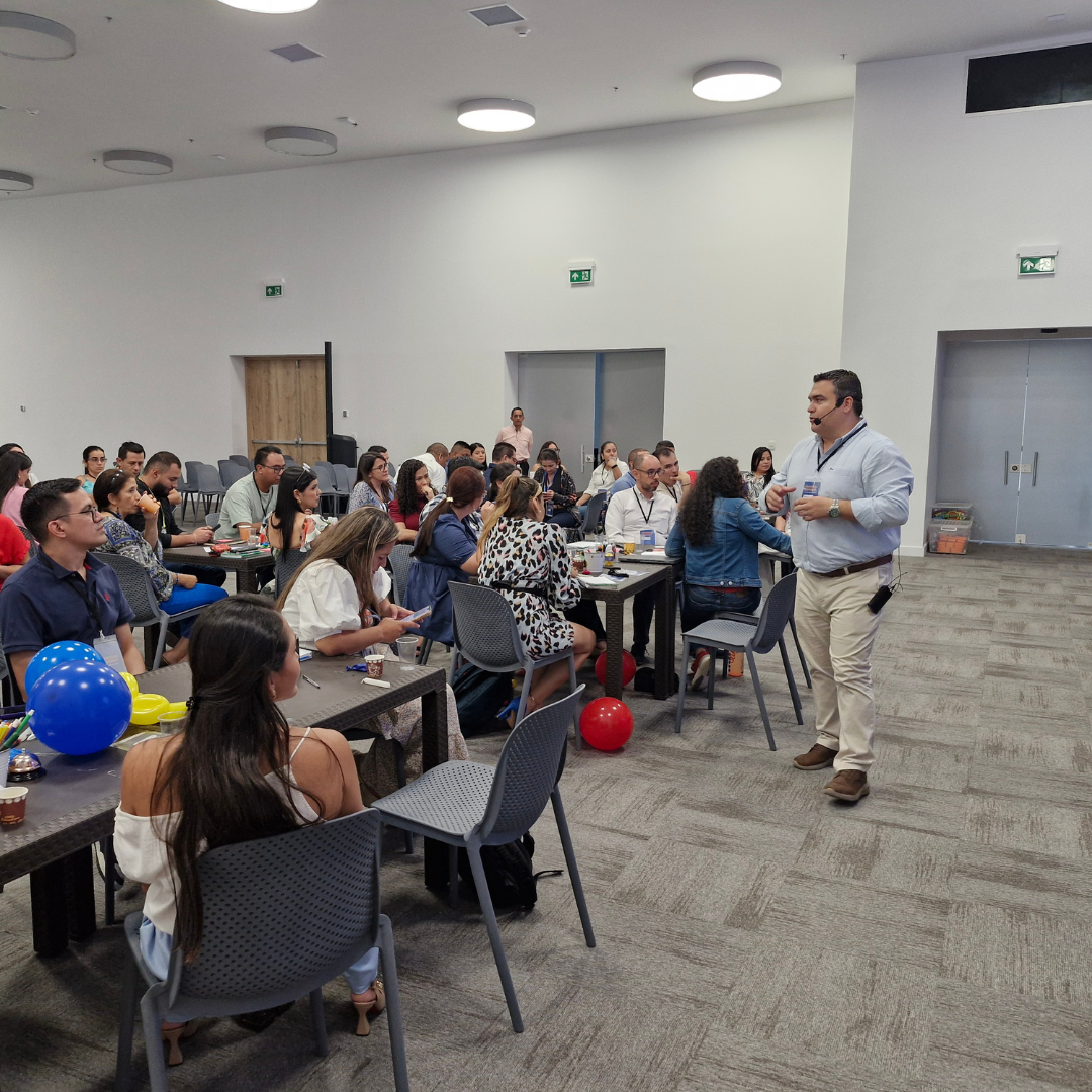 Taller experiencial con equipos trabajando en mesas de grupo