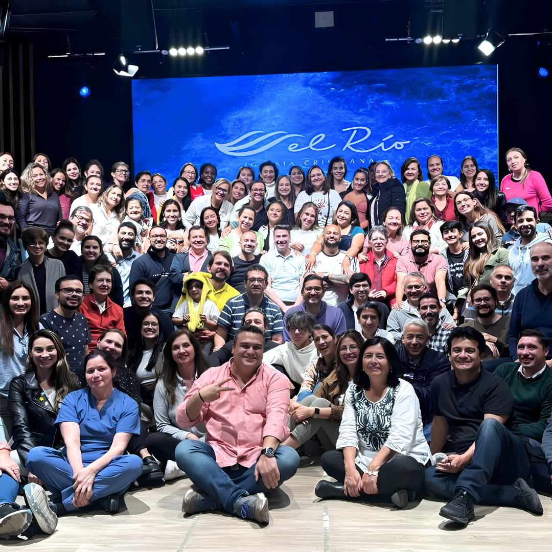 Grupo completo de participantes en una experiencia de equipo en auditorio